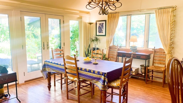 dining space featuring a chandelier, french doors, and wood-type flooring