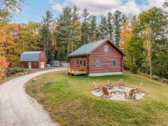 view of side of home with an outdoor fire pit, a yard, an outdoor structure, and a deck