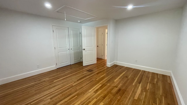 unfurnished bedroom with hardwood / wood-style flooring and a closet