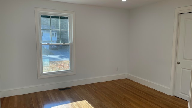 unfurnished room with a wealth of natural light and hardwood / wood-style floors