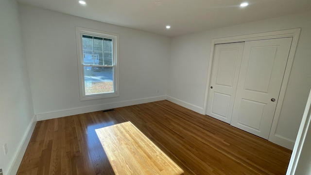 unfurnished bedroom with a closet and dark hardwood / wood-style floors