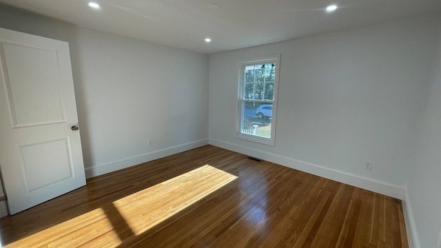 empty room with dark hardwood / wood-style flooring