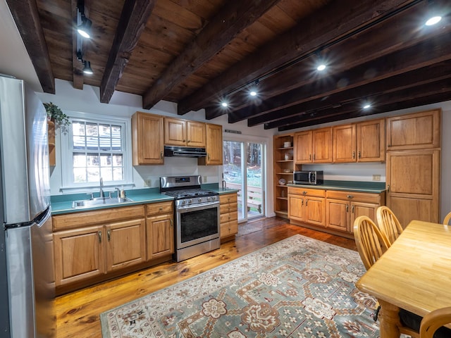 kitchen with sink, beam ceiling, appliances with stainless steel finishes, wooden ceiling, and light wood-type flooring