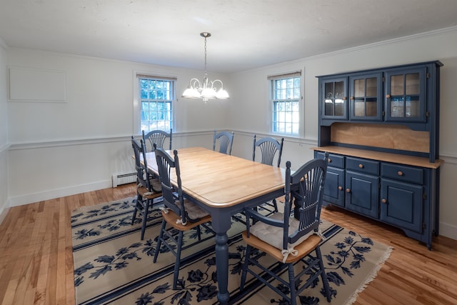 dining room with ornamental molding, light hardwood / wood-style flooring, plenty of natural light, and a chandelier