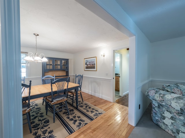 dining area with hardwood / wood-style floors and an inviting chandelier