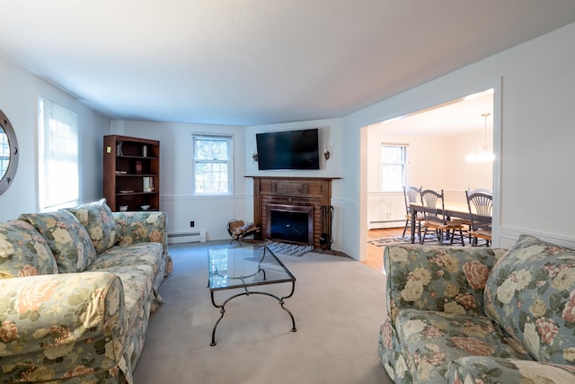 carpeted living room with a brick fireplace, an inviting chandelier, and baseboard heating