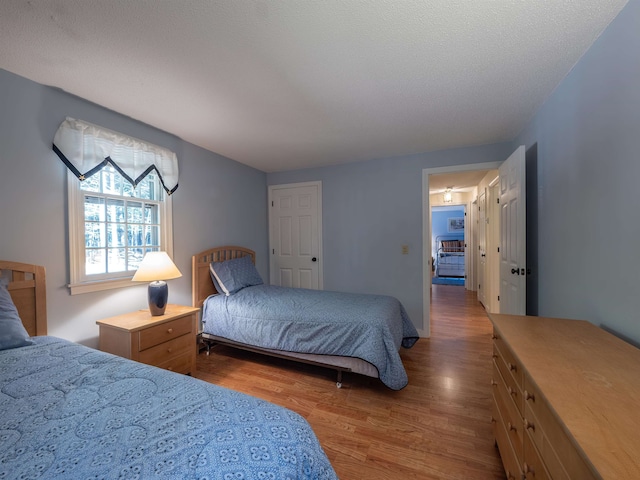 bedroom with wood-type flooring and a textured ceiling