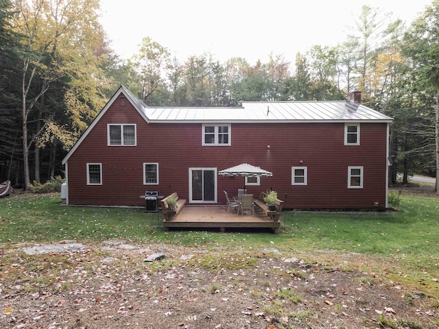 rear view of property with a yard and a wooden deck