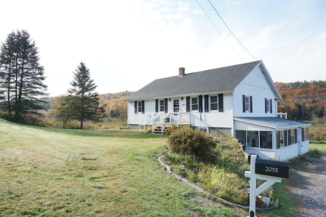 view of front of property with a front yard and a sunroom