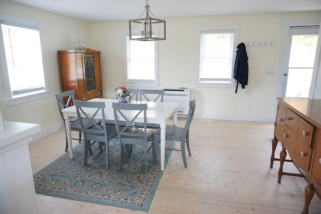 dining room with heating unit, a chandelier, and light wood-type flooring