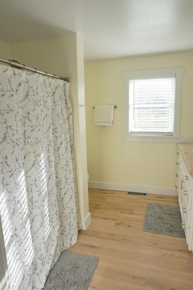 bathroom featuring vanity, hardwood / wood-style flooring, and toilet