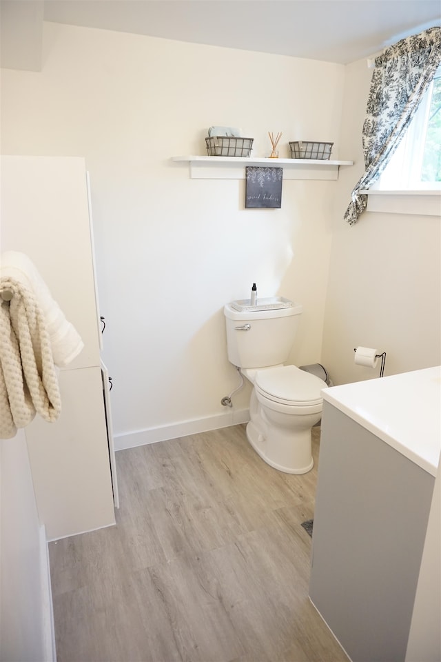 bathroom with hardwood / wood-style floors and toilet