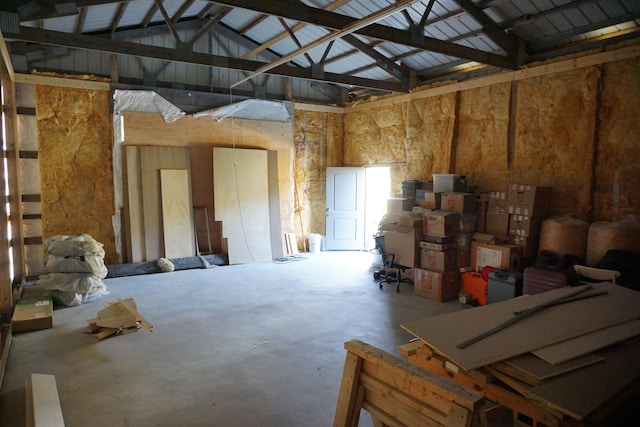 miscellaneous room with high vaulted ceiling and concrete flooring