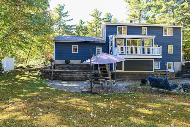 rear view of property featuring a lawn and a patio area