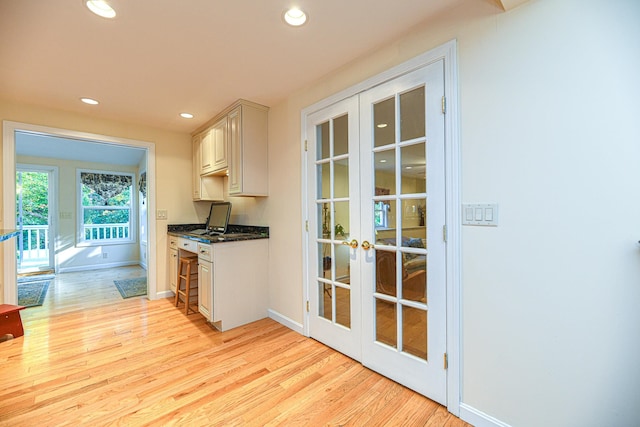 kitchen with light wood-type flooring, french doors, and white cabinets