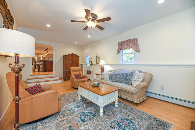 living room with ceiling fan, a baseboard heating unit, and wood-type flooring