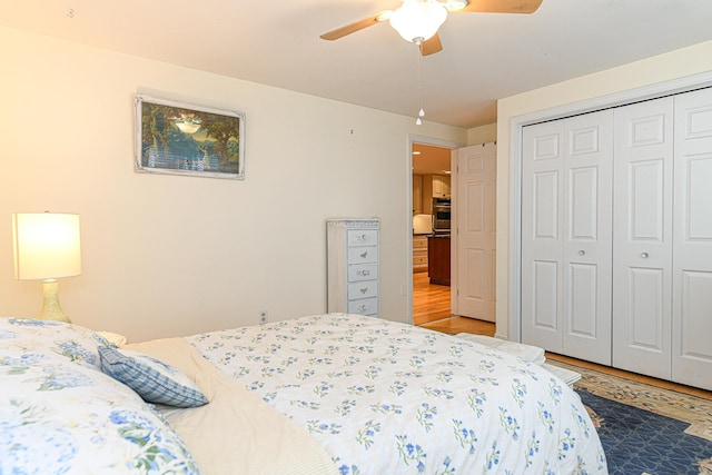 bedroom with ceiling fan, a closet, and hardwood / wood-style floors