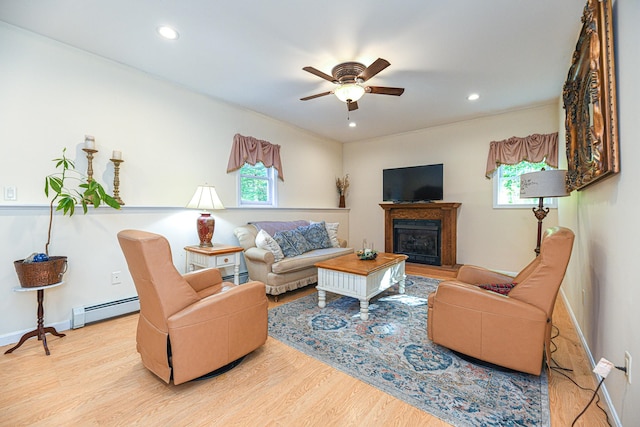 living room with ceiling fan, plenty of natural light, a baseboard radiator, and light hardwood / wood-style floors