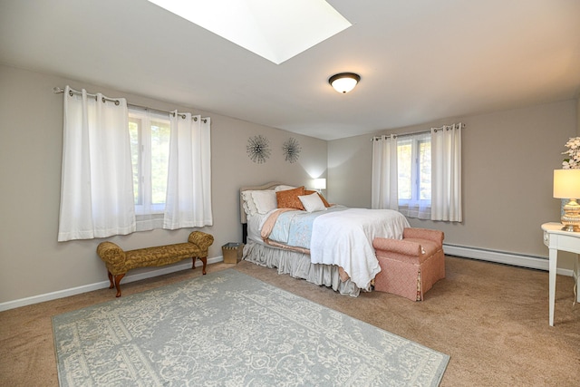 bedroom with a skylight, a baseboard heating unit, and light colored carpet