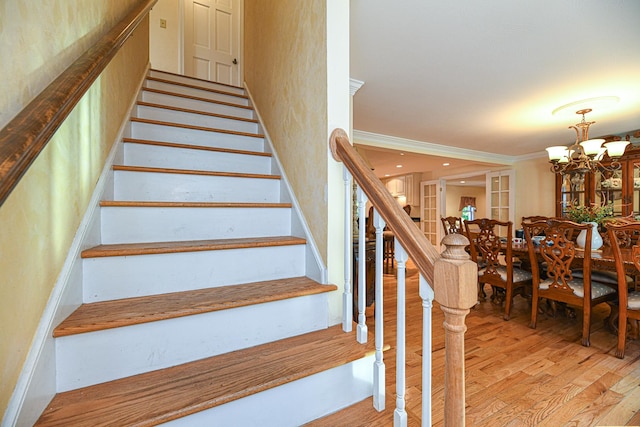 staircase featuring hardwood / wood-style floors and a chandelier