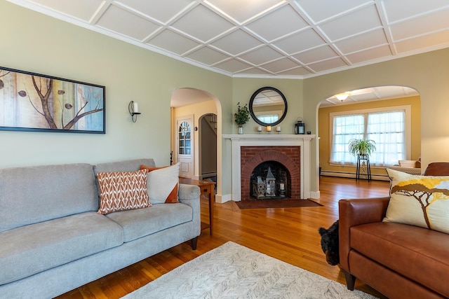 living room with coffered ceiling, a fireplace, baseboard heating, and hardwood / wood-style floors