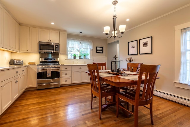 dining area featuring an inviting chandelier, ornamental molding, light hardwood / wood-style flooring, and sink