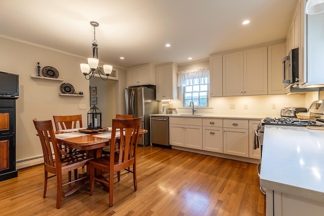 kitchen with decorative light fixtures, stainless steel appliances, and white cabinetry