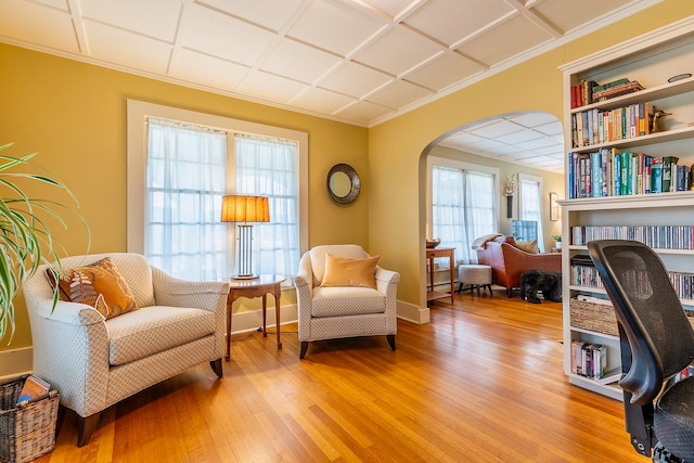 living area with light hardwood / wood-style flooring and crown molding