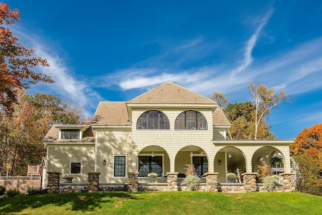 back of property with a yard and covered porch