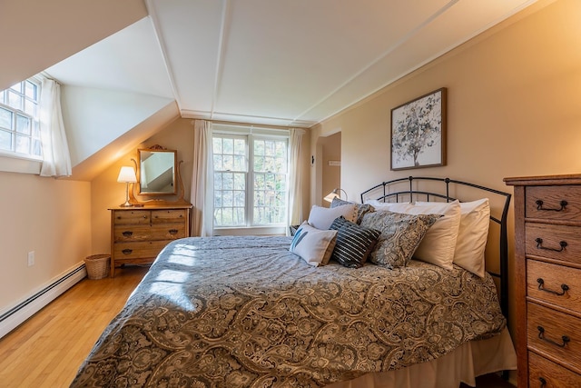 bedroom featuring wood-type flooring, baseboard heating, and lofted ceiling