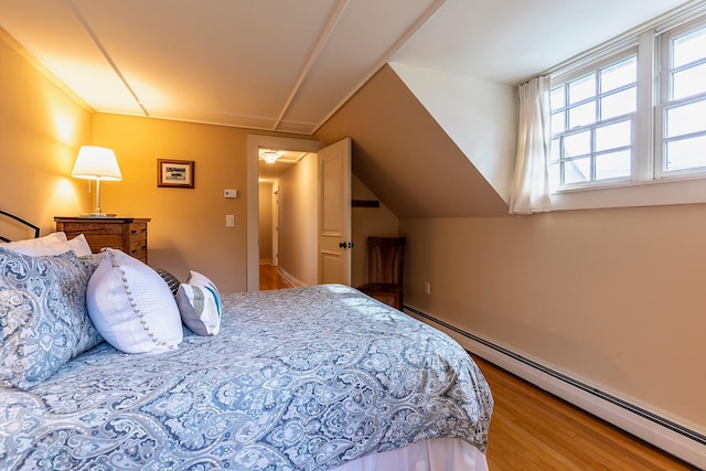 bedroom with hardwood / wood-style flooring, lofted ceiling, and baseboard heating