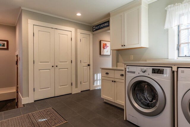 washroom with independent washer and dryer, crown molding, dark tile patterned floors, and cabinets