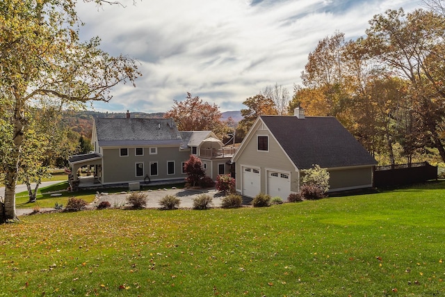 back of house with a yard and a garage