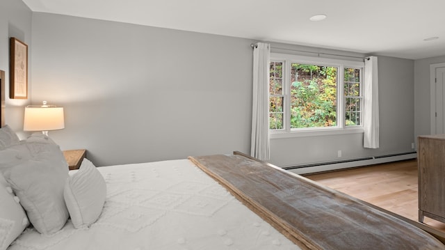 bedroom featuring baseboard heating and hardwood / wood-style flooring