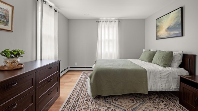 bedroom with light wood-type flooring and a baseboard radiator