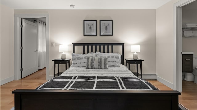 bedroom with light hardwood / wood-style flooring and a baseboard radiator