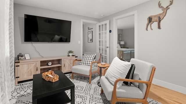 living room with french doors and light wood-type flooring