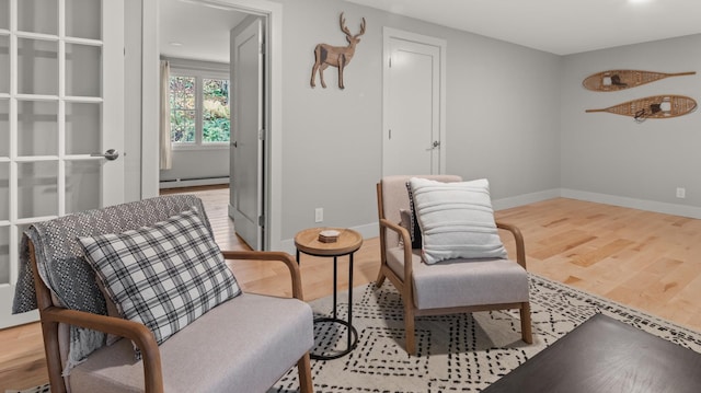 living area featuring a baseboard radiator and light hardwood / wood-style flooring