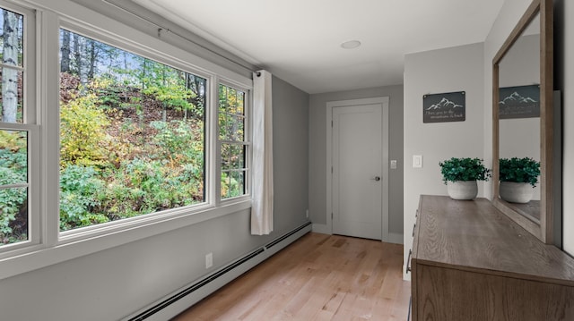 entryway with a healthy amount of sunlight, light hardwood / wood-style flooring, and a baseboard radiator