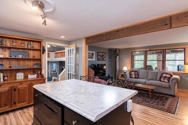 kitchen with a kitchen island, light hardwood / wood-style floors, and a textured ceiling