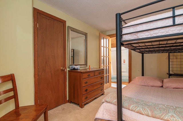 bedroom featuring a textured ceiling and light colored carpet