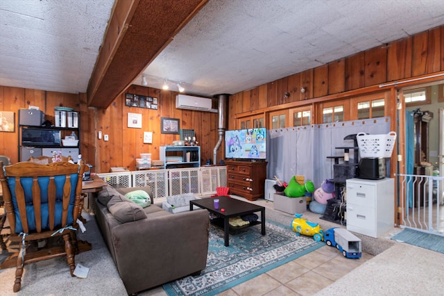 tiled living room featuring an AC wall unit, wooden walls, and a textured ceiling