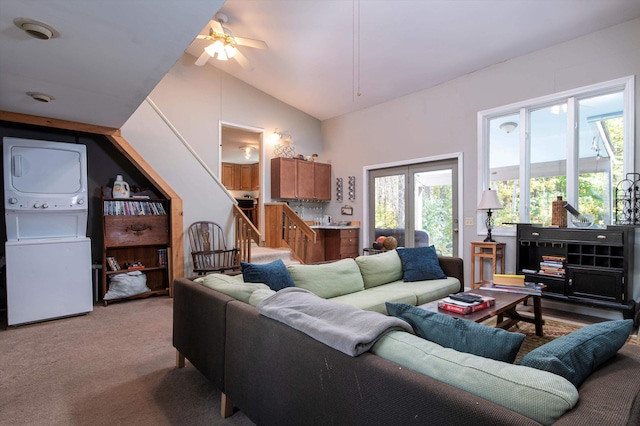 carpeted living room featuring lofted ceiling, stacked washer / drying machine, and ceiling fan