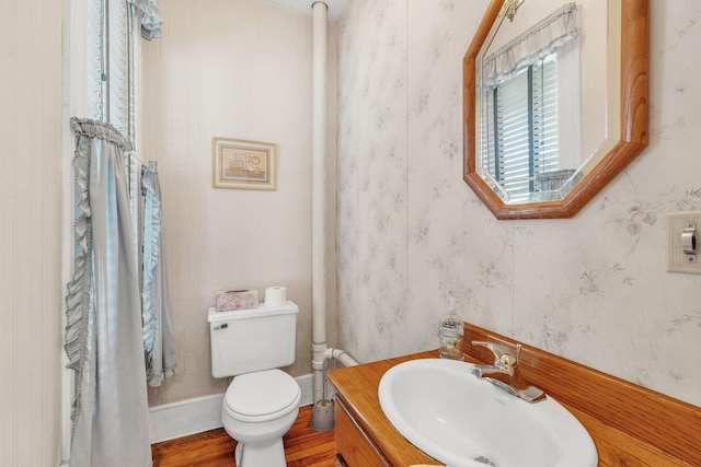 bathroom with toilet, vanity, and hardwood / wood-style flooring