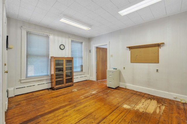 spare room with a baseboard heating unit and hardwood / wood-style flooring