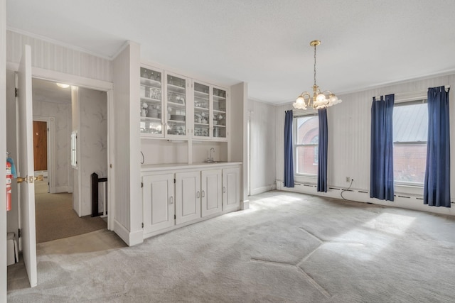 unfurnished dining area with light carpet, wet bar, a chandelier, and ornamental molding