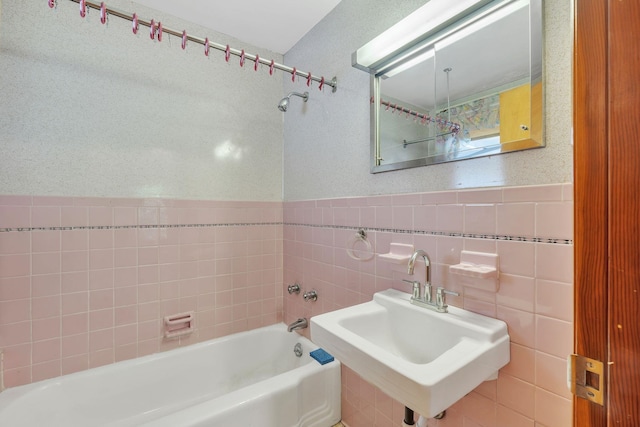 bathroom with tiled shower / bath, tile walls, and sink