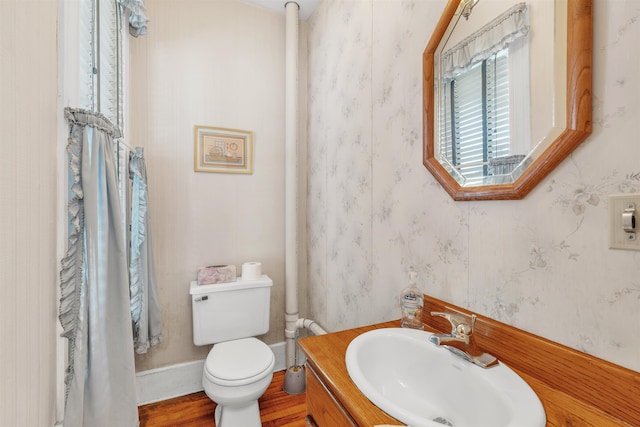 bathroom with hardwood / wood-style floors, vanity, and toilet