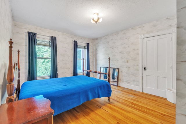 bedroom with a textured ceiling and hardwood / wood-style flooring