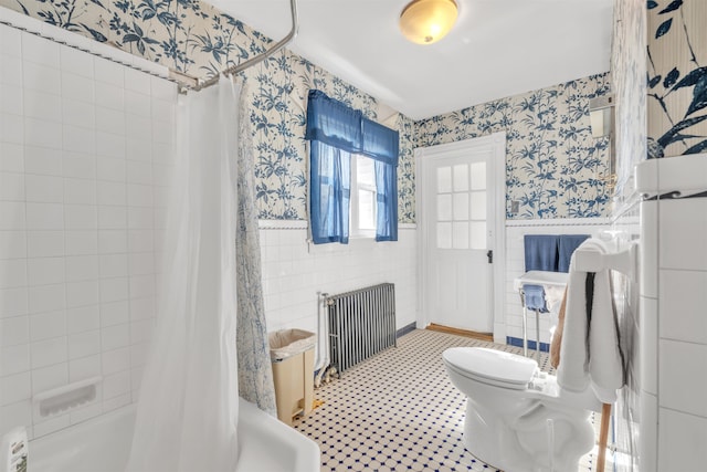 bathroom featuring radiator, shower / bath combo with shower curtain, tile walls, and toilet